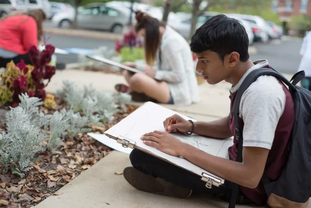 Student in drawing class sitting outside